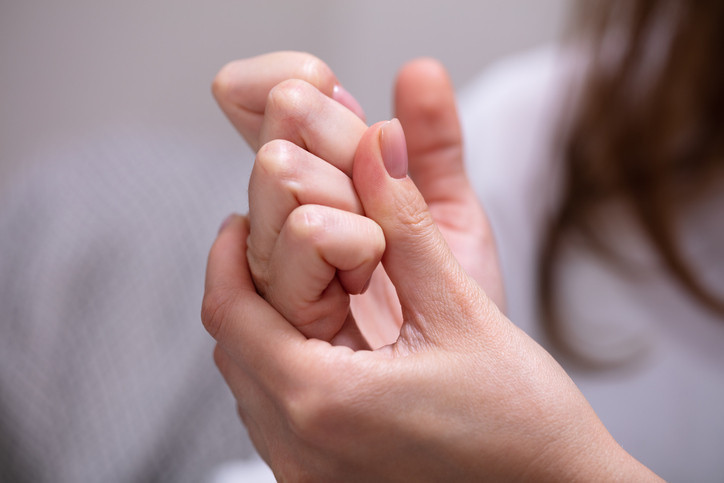 Person cracking their fingers with a close-up view of hand joints, illustrating the habit of finger cracking.